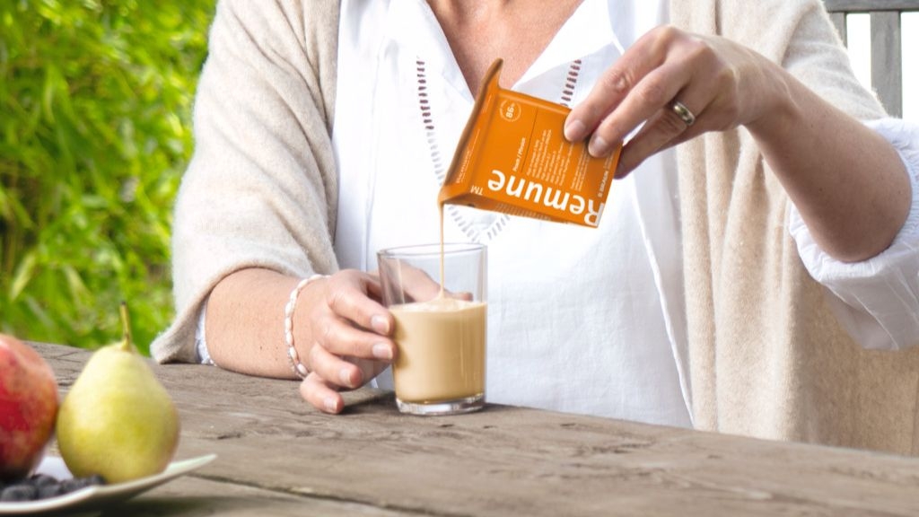A woman pours Remune into a glass