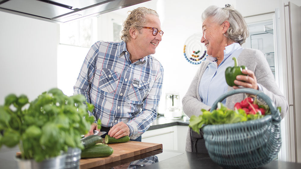 uomo e donna preparano insieme le verdure
