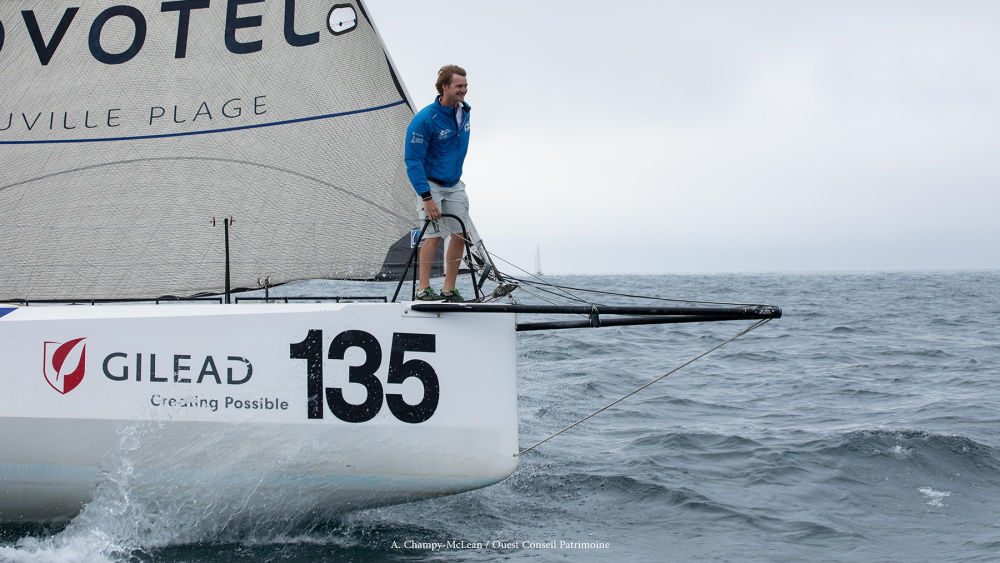 Ein Mann steht am Rand einer fahrenden Yacht