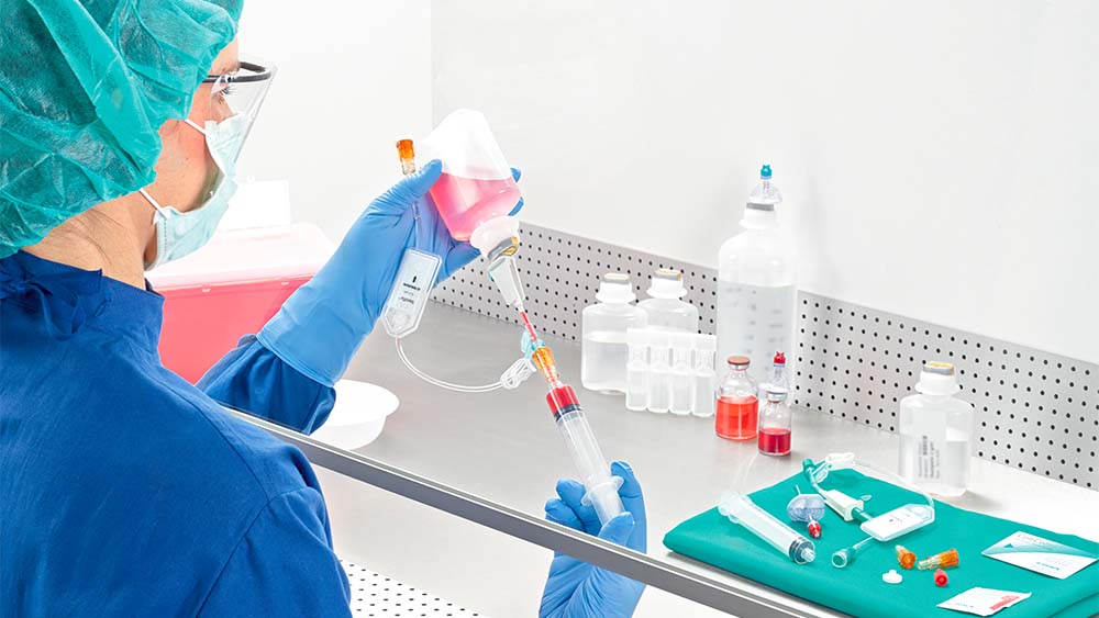 Apotheker zieht Spritze unter Lamina-Luftstrom