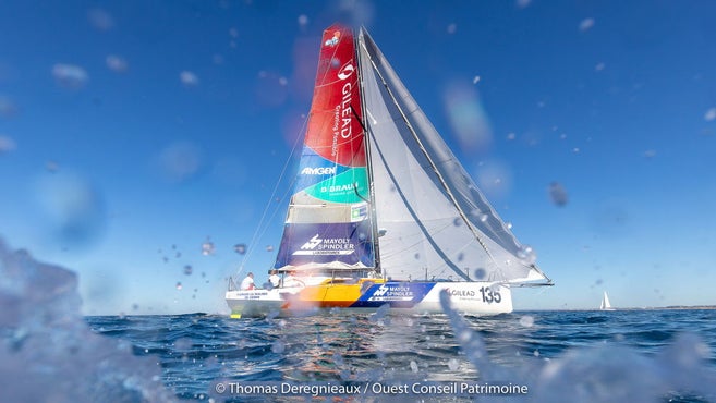 Un enorme yacht in acqua con una vela colorata