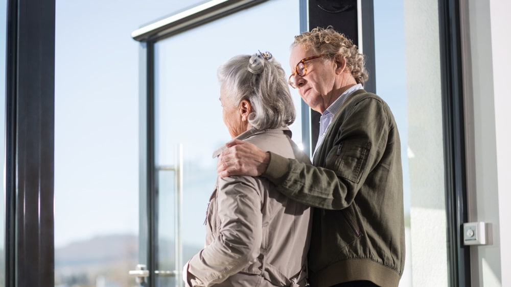 man legt arm op schouder van vrouw