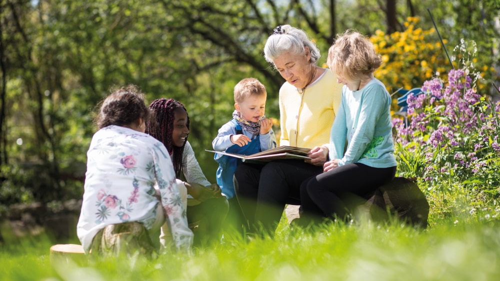 oudere vrouw leest kinderen een boek voor