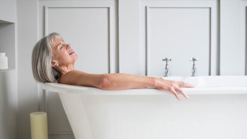 Una mujer de mediana edad está tumbada en el baño