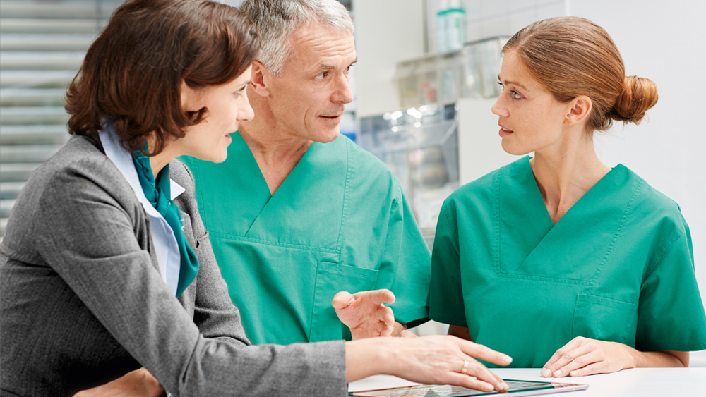 Drei medizinische Fachkräfte beraten sich gegenseitig