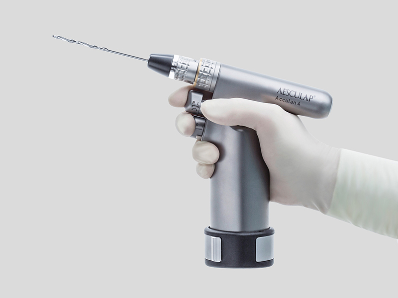 Ein chirurgisches Motorensystem wird mit einer Hand mit Handschuh gehalten