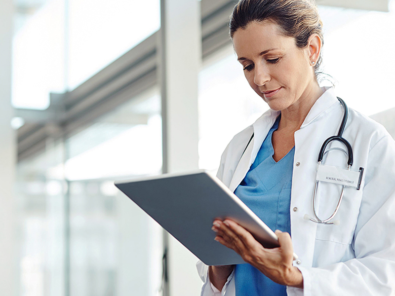 Female doctor looks on a tablet in her hands