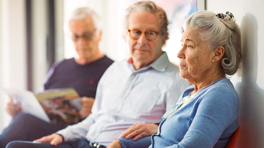 Los pacientes de edad avanzada están esperando en la sala de espera de una consulta médica.