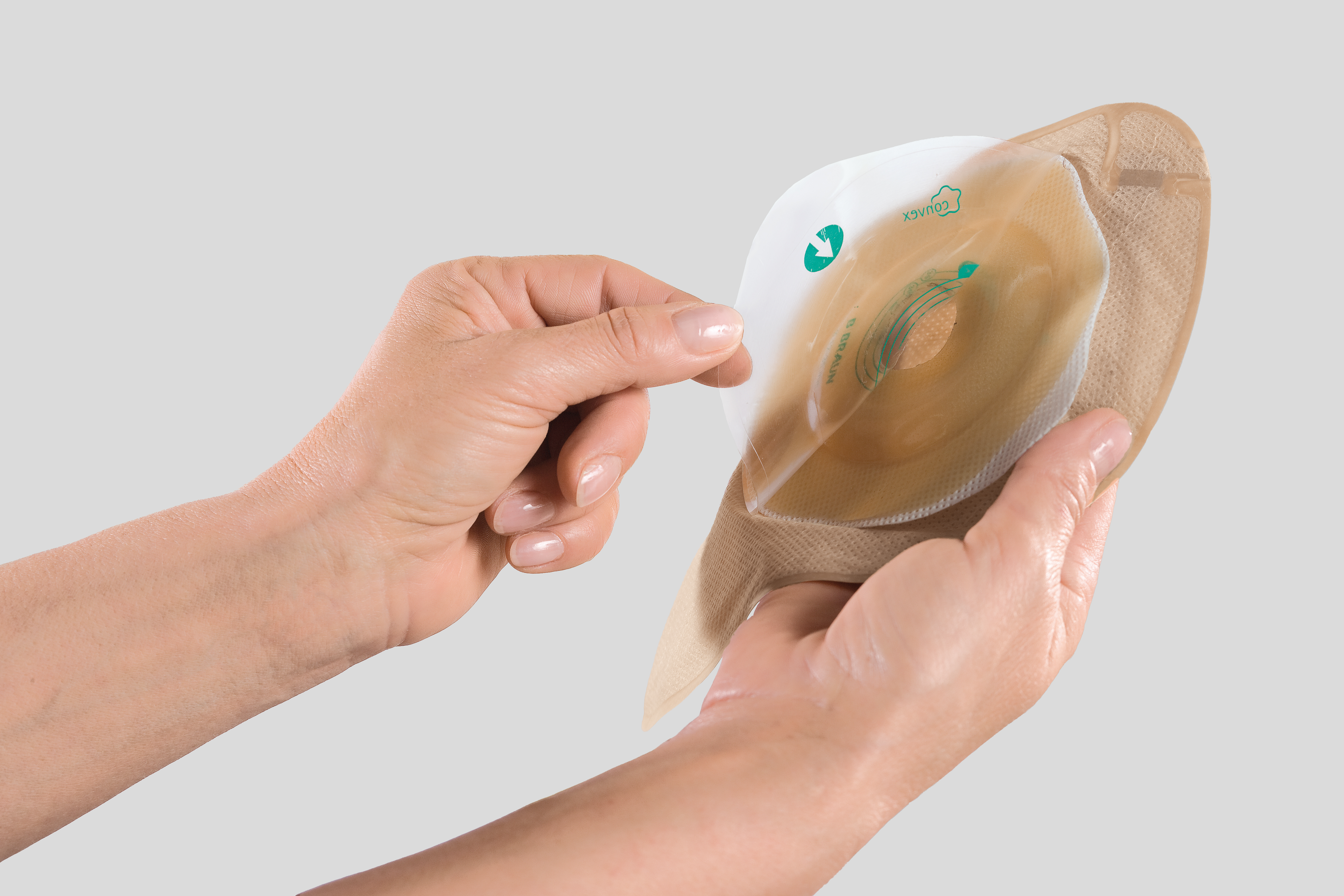 Dos manos sosteniendo una bolsa de ostomía con una lámina convexa