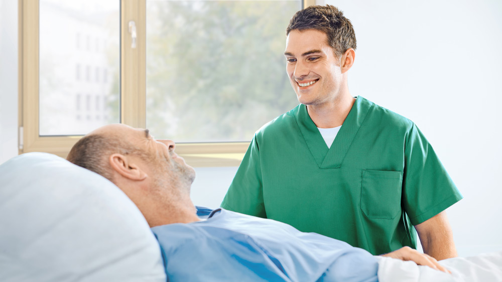 Az ágy mellől a beteggel beszélő ápoló